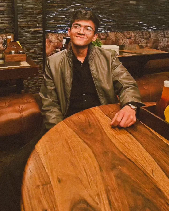Ankit at a table, smiling